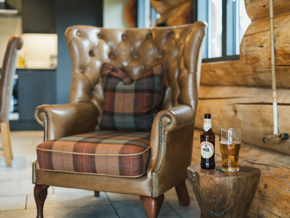 A living room with an armchair and drinks at Keepers Cabin Addingham