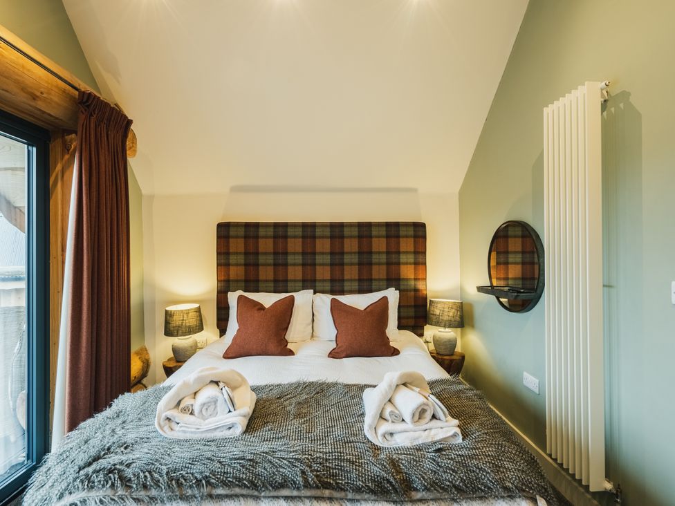 A bedroom with a bed and bedside tables at Keepers Cabin in Addingham