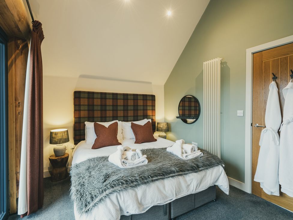 A bedroom with a bed and bedside lamps at Keepers Cabin Addingham