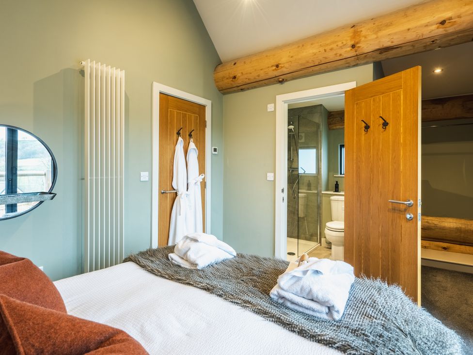 A bedroom with a bed and attached bathroom at Keepers Cabin in Addingham