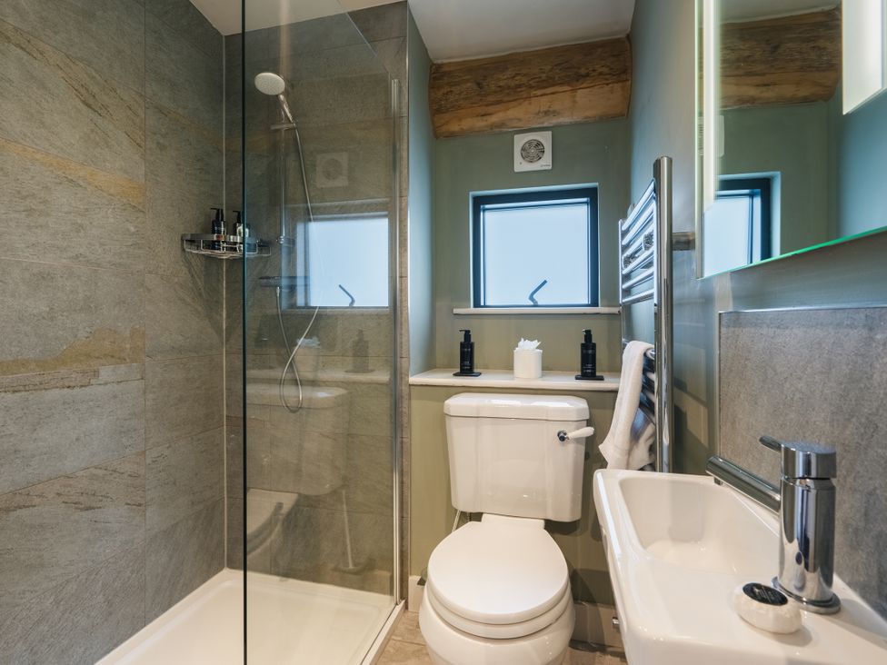 A bathroom featuring a shower, toilet, and sink at Keepers Cabin in Addingham