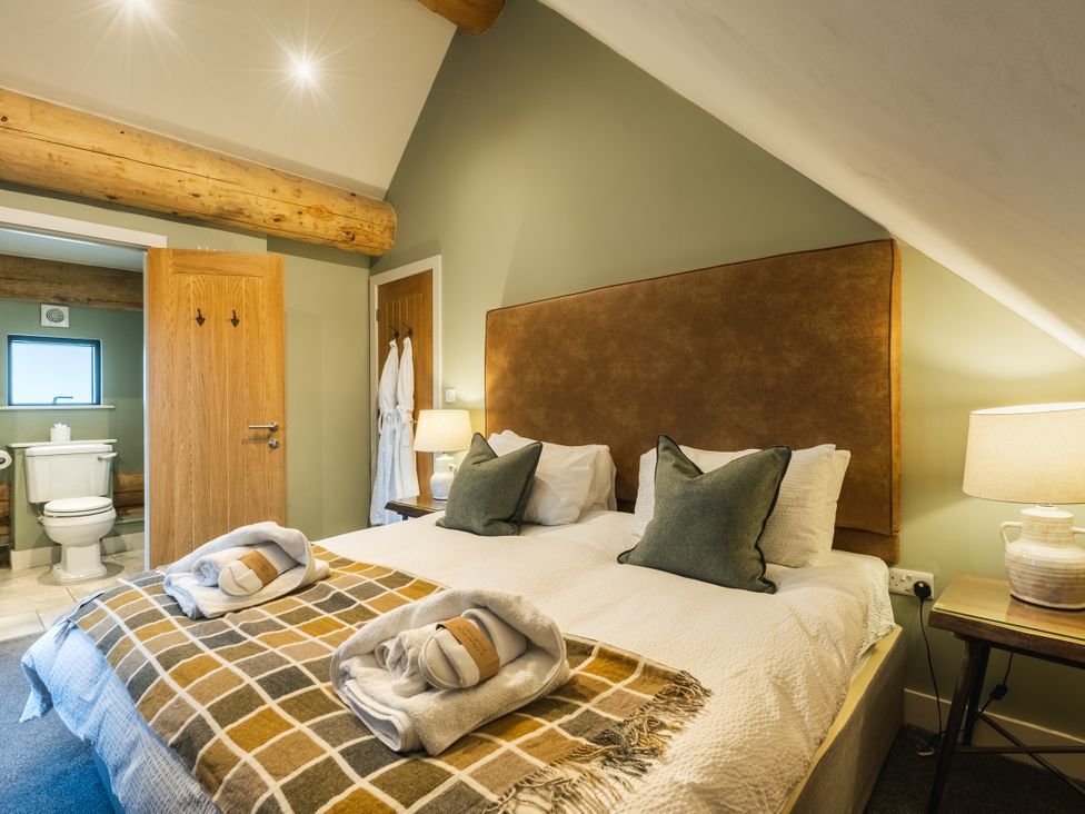 A bedroom with a bed and attached bathroom at Keepers Cabin in Addingham