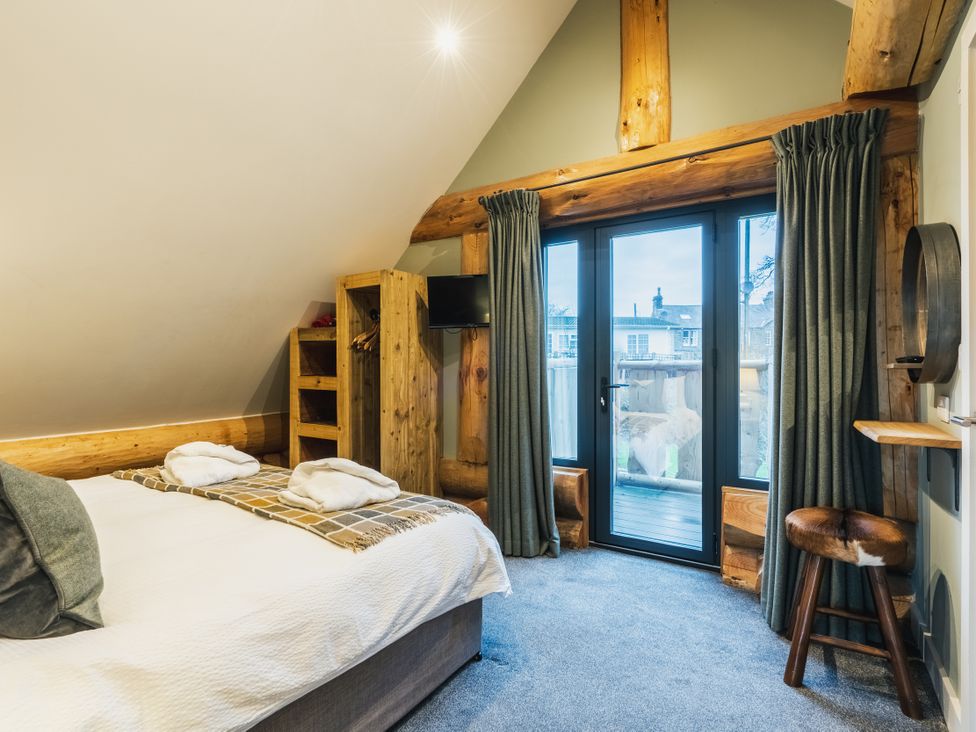 A bedroom with a bed and shelves at Keepers Cabin in Addingham