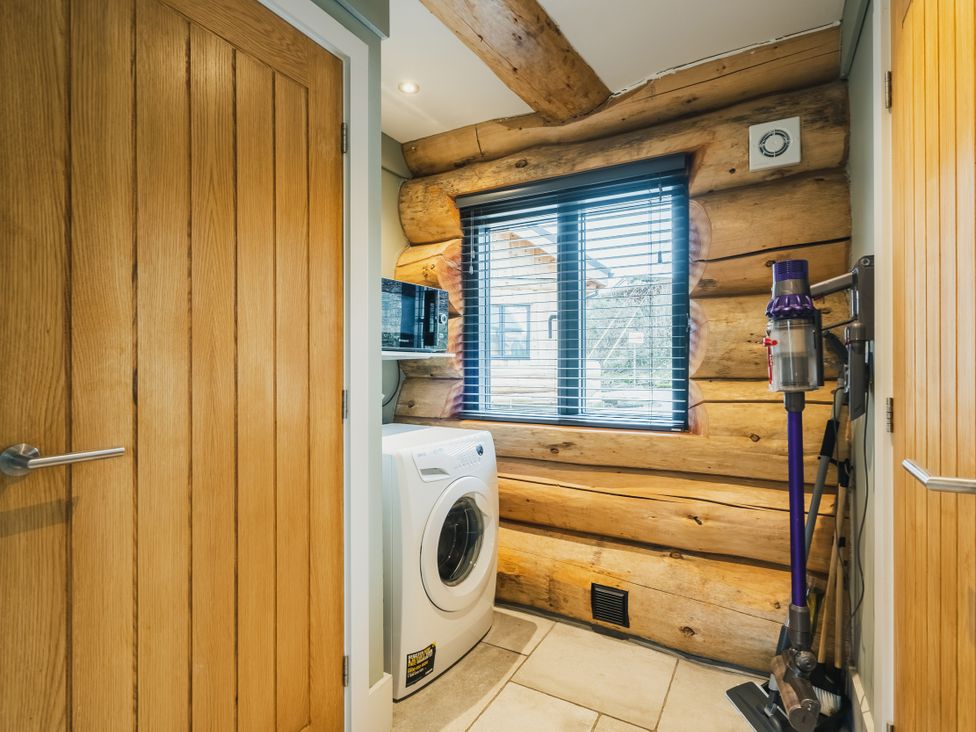 A laundry room with a washing machine and window at Keepers Cabin Addingham