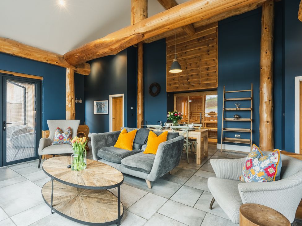 A living room with a coffee table and dining area at The Farmhouse in Addingham
