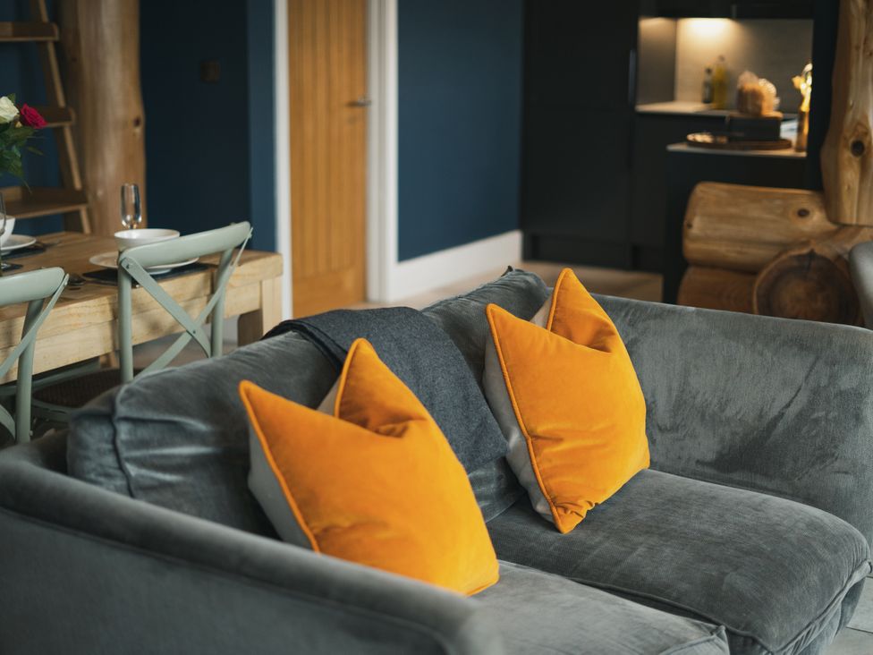 A living room with a sofa and dining area at The Farmhouse in Addingham