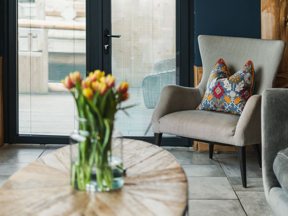 A living room with a vase of flowers on a table at The Farmhouse in Addingham