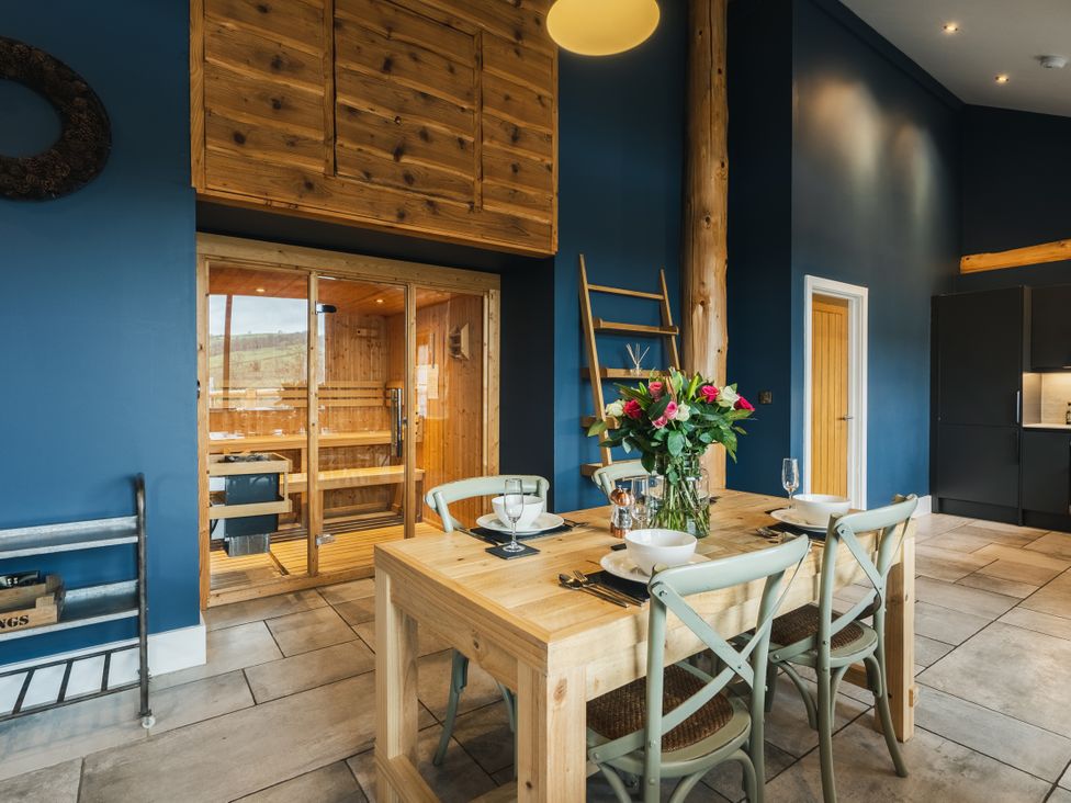 A dining room with a table and chairs next to a sauna at The Farmhouse in Addingham