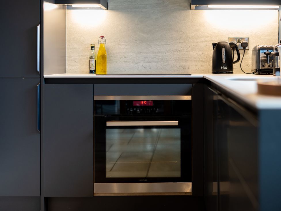 A kitchen with an oven, kettle, and olive oil at The Farmhouse in Addingham