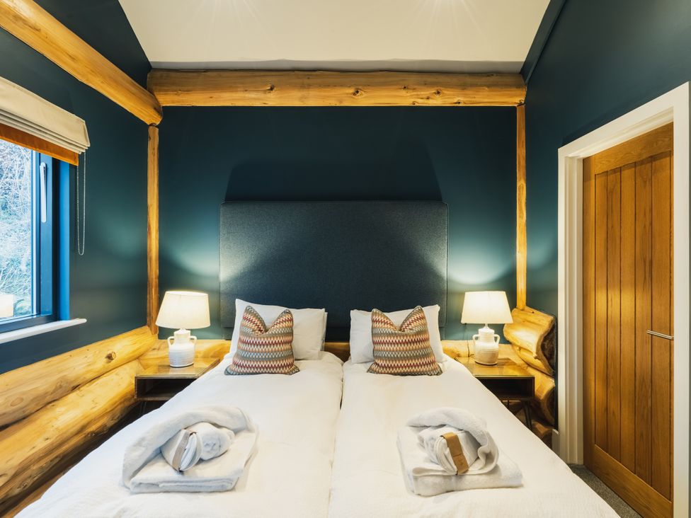 A bedroom with two beds and lamps at The Farmhouse in Addingham