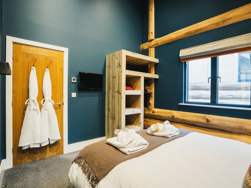 A bedroom with a bed and towels at The Farmhouse in Addingham