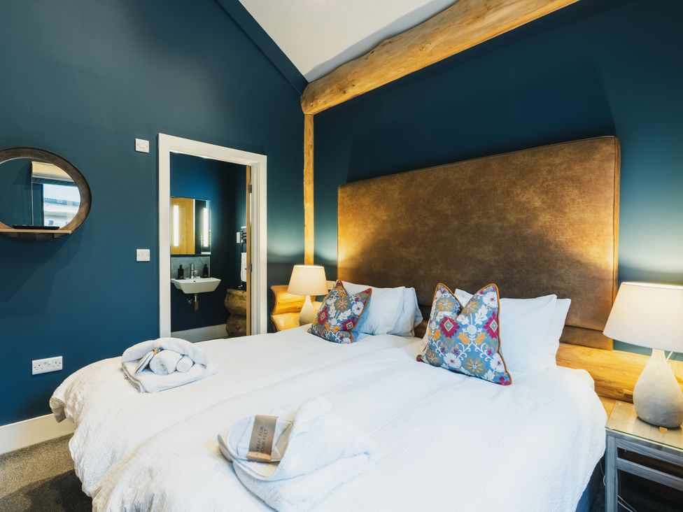 A bedroom with two beds and a mirror at The Farmhouse in Addingham