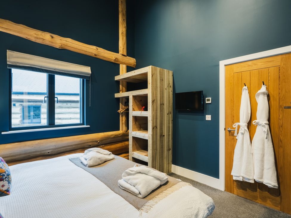 A bedroom with a bed and shelves at The Farmhouse in Addingham