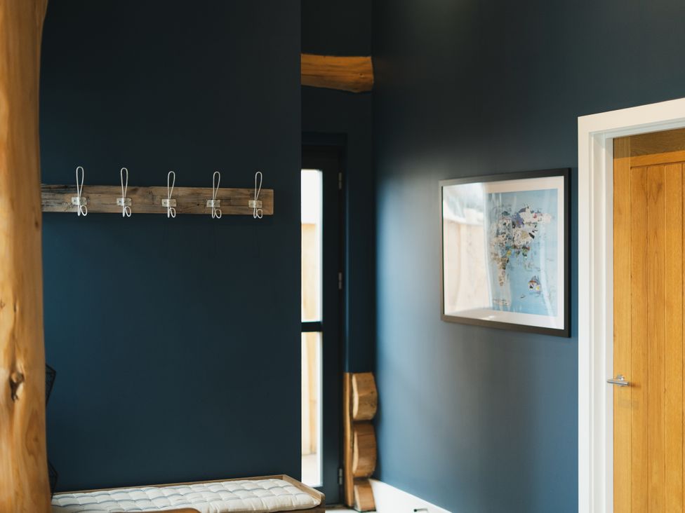 An entrance hall with a bench and coat hooks at The Farmhouse in Addingham