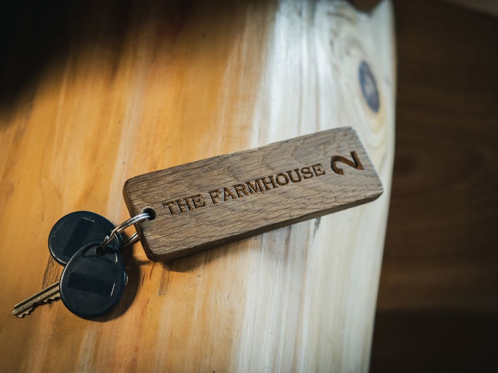 A key and wooden key tag for The Farmhouse in Addingham