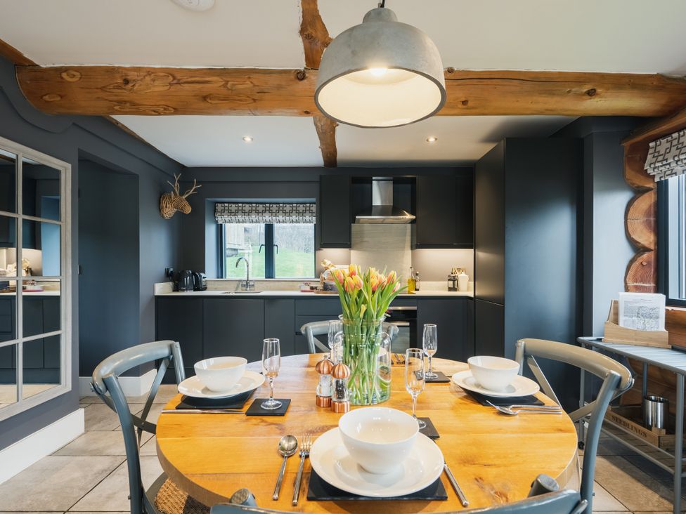 A kitchen with a table set and flowers in a vase at Apres Ski in Addingham