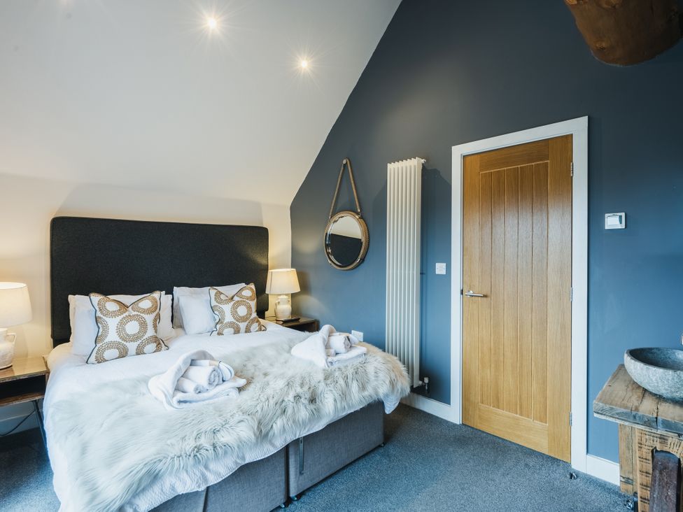 A bedroom with a bed and a door at Apres Ski in Addingham