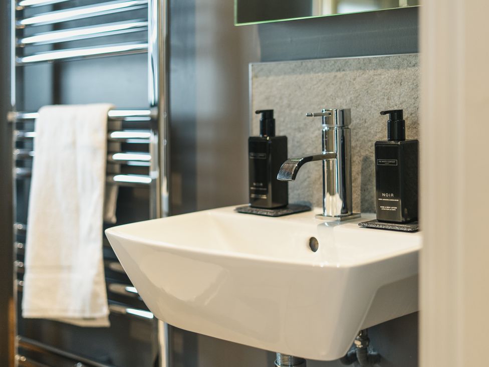 A bathroom with sink and soap dispensers at Apres Ski in Addingham