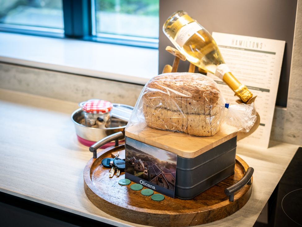 A kitchen countertop with bread on a board, a wine bottle, and a jar at Apres Ski in Addingham