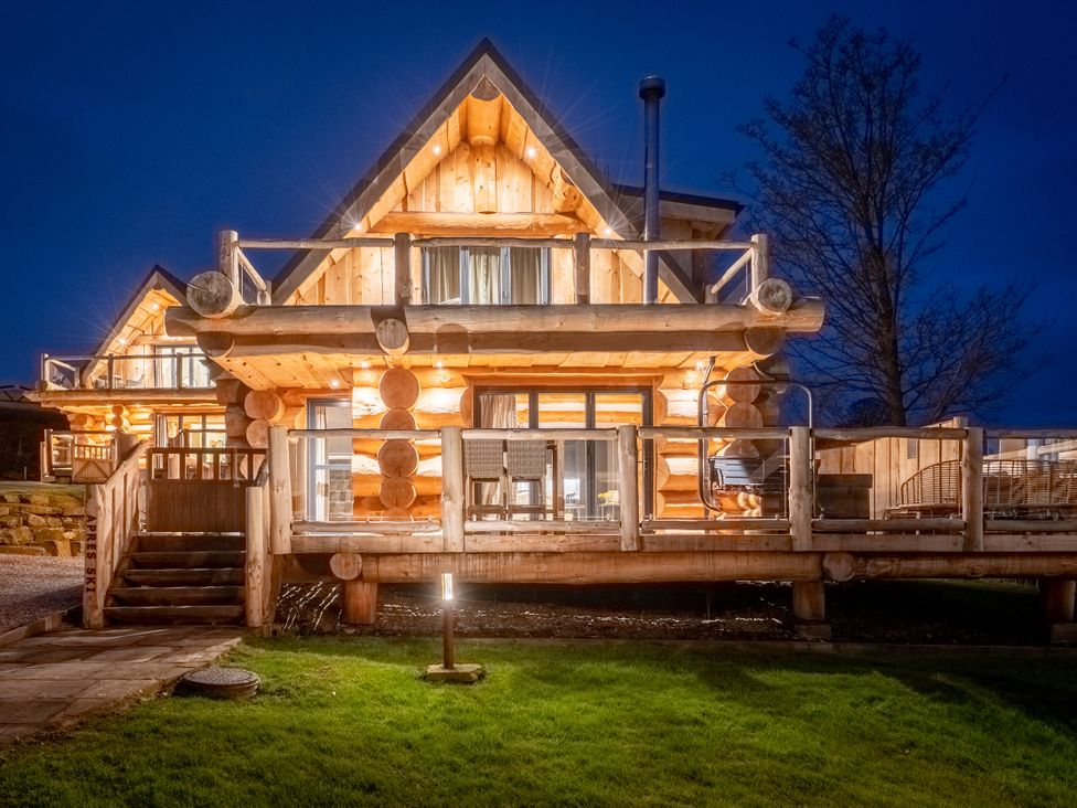 A log cabin with a deck and stairs at Apres Ski in Addingham
