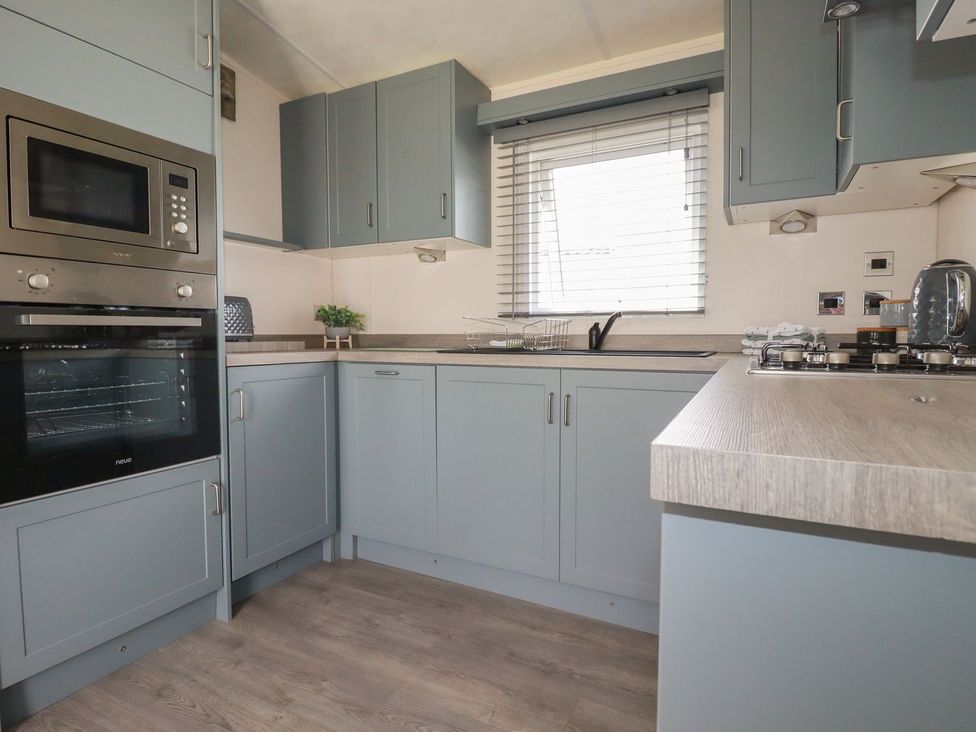 A kitchen with cabinets and appliances at No. 4 Fistral in Newquay