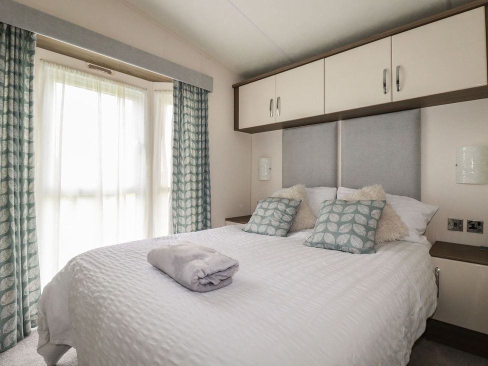 A bedroom with a bed and cushions at No. 4 Fistral in Newquay