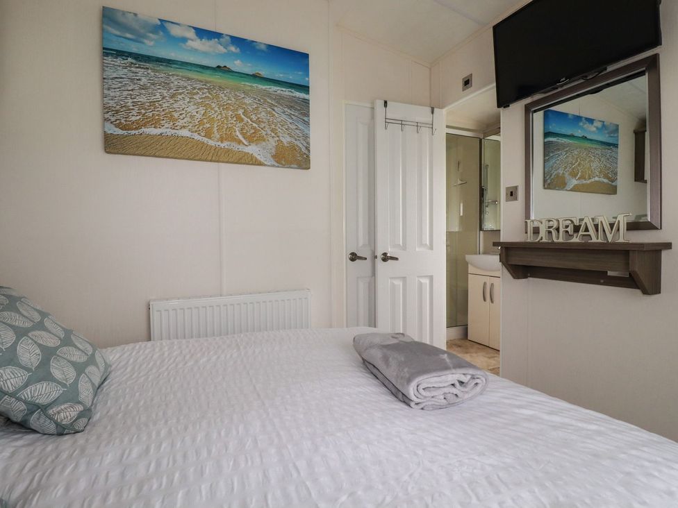 A bedroom with a bed and television at No. 4 Fistral in Newquay