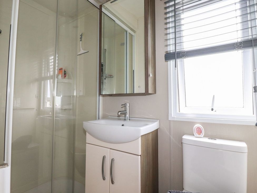 A bathroom with a shower, sink, and toilet at No. 4 Fistral in Newquay