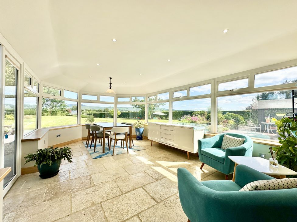 A conservatory with a table and chairs at Seeview in Charleville