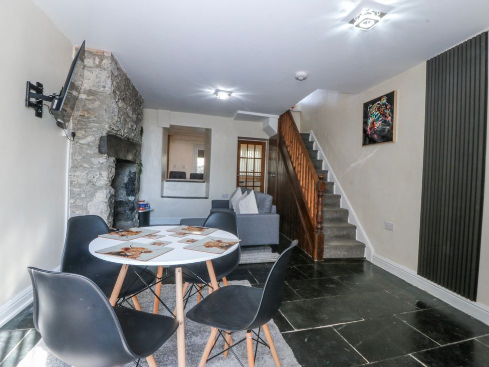 A living room with a stone wall and stairs at Tegfan in Garndolbenmaen near Porthmadog