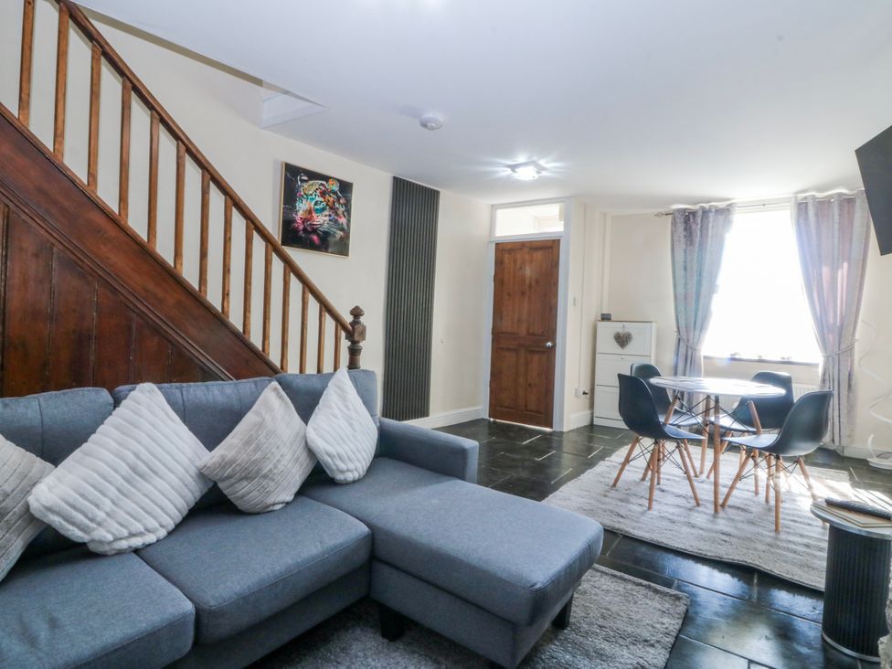 A living room with a sofa and table at Tegfan in Garndolbenmaen near Porthmadog