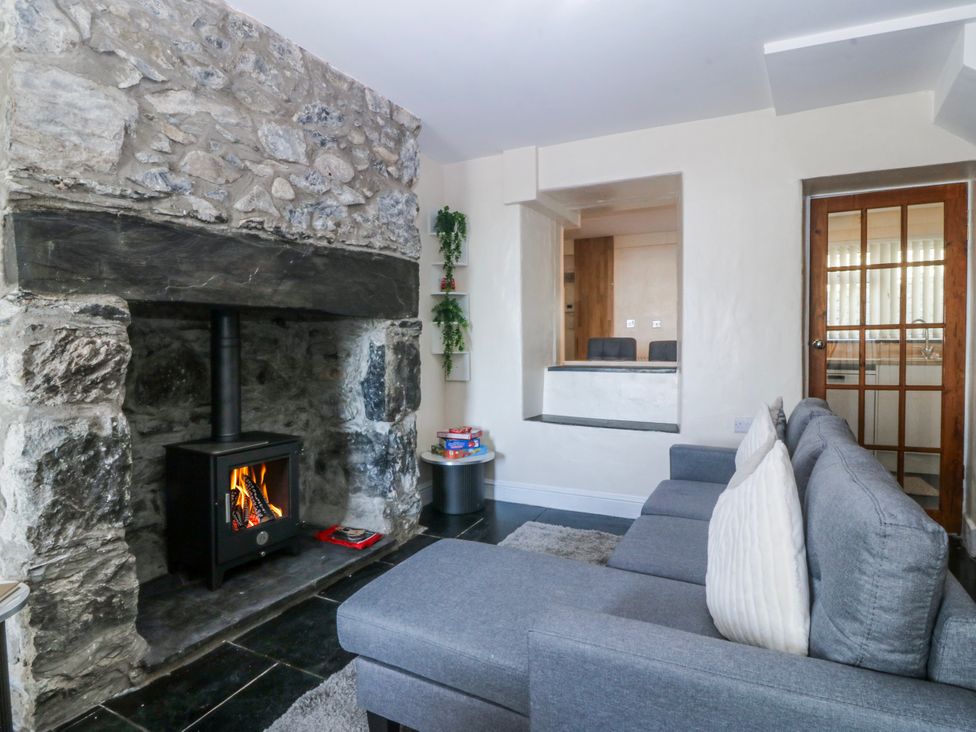 A sitting room with a fireplace and sofa at Tegfan in Garndolbenmaen near Porthmadog