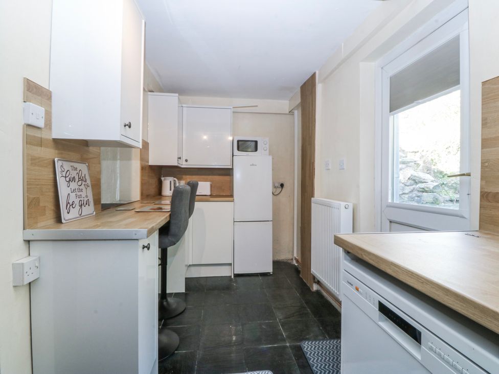 A kitchen with appliances and a window at Tegfan in Garndolbenmaen near Porthmadog