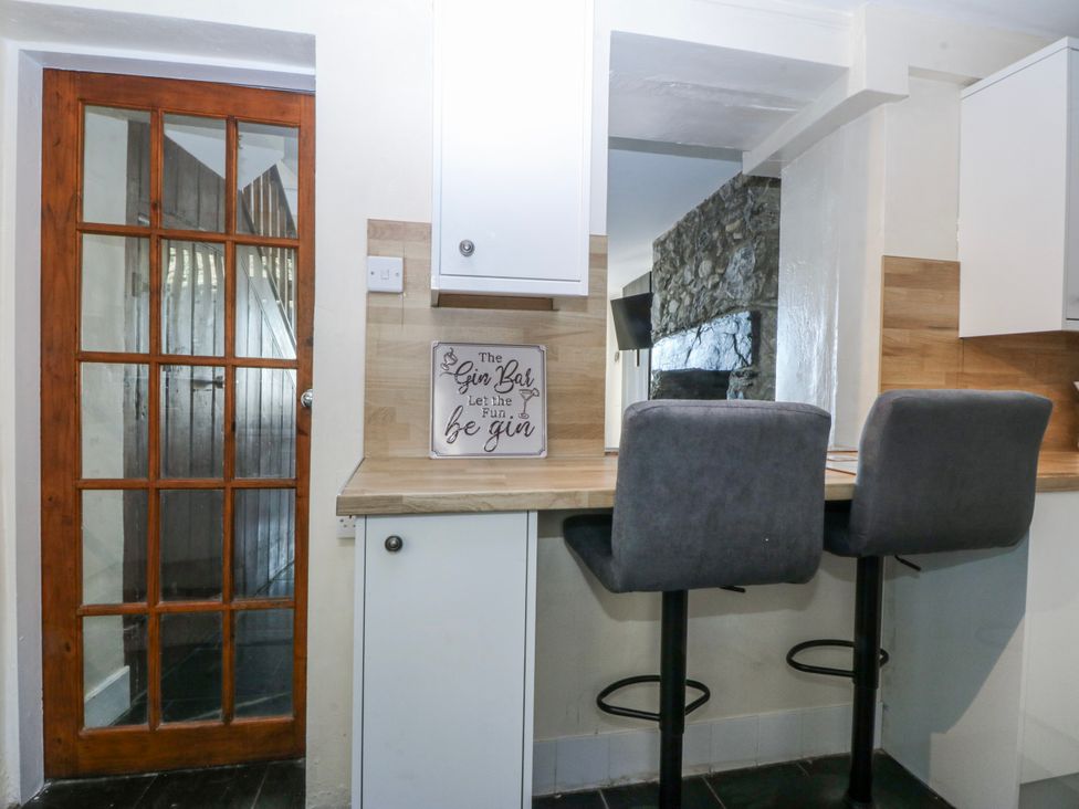 A kitchen with stools and a sign at Tegfan in Garndolbenmaen near Porthmadog