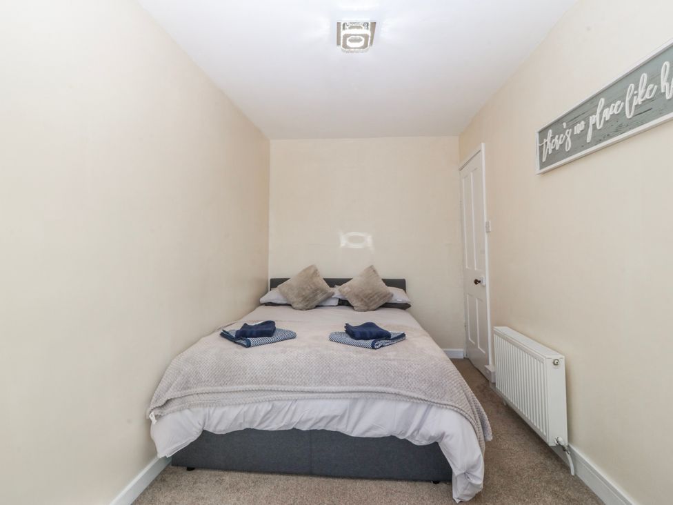 A bedroom with a bed and pillows at Tegfan in Garndolbenmaen near Porthmadog