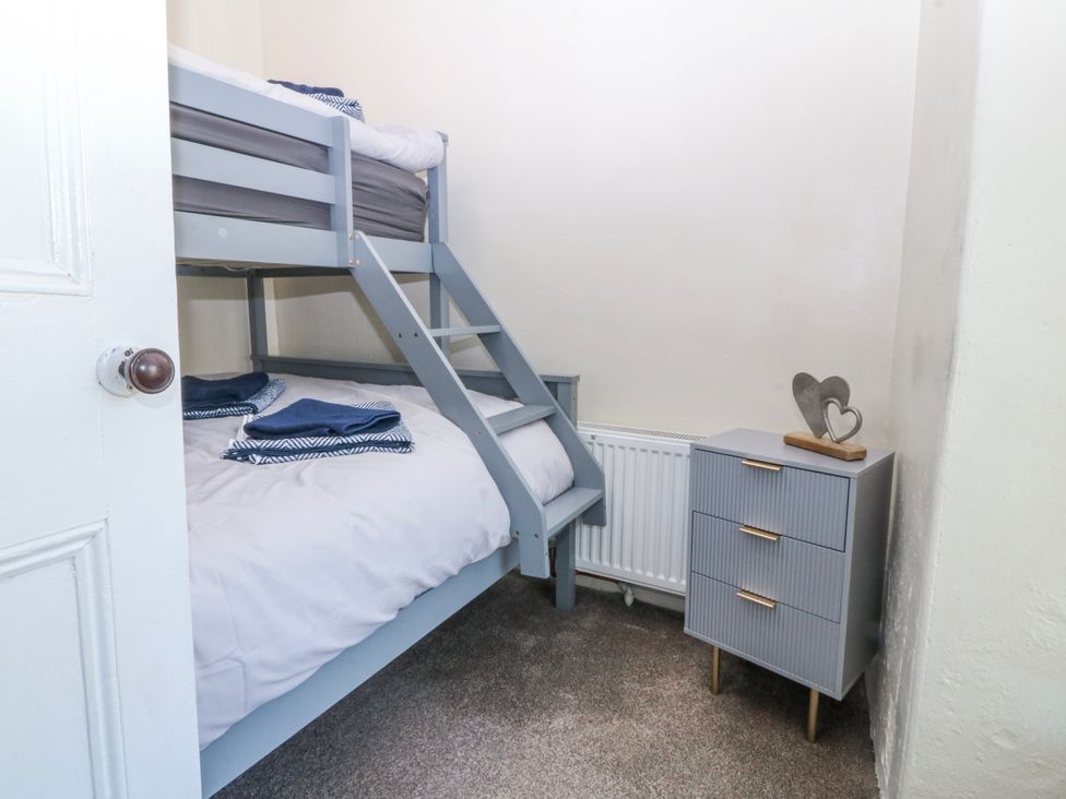A bedroom with a bunk bed and a nightstand at Tegfan in Garndolbenmaen near Porthmadog