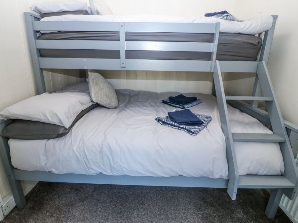 A bunk bed with pillows and towels in a bedroom at Tegfan, Garndolbenmaen near Porthmadog