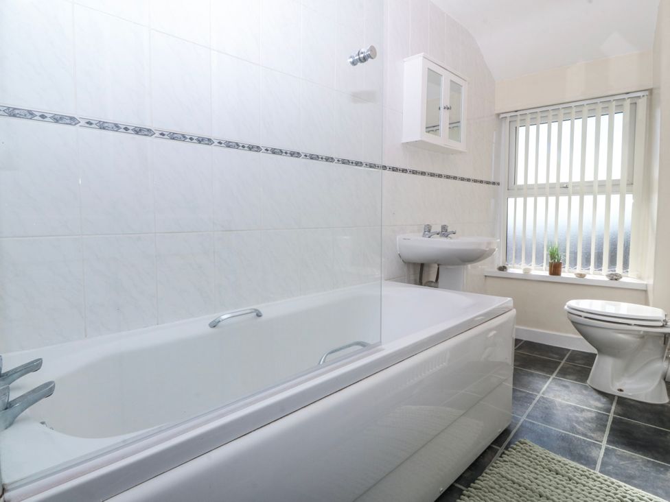 A bathroom with a bathtub, sink, and toilet at Tegfan in Garndolbenmaen near Porthmadog