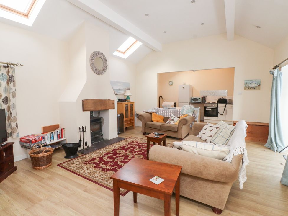 A living room with a fireplace and sofa at Swallow Cottage in Llangefni