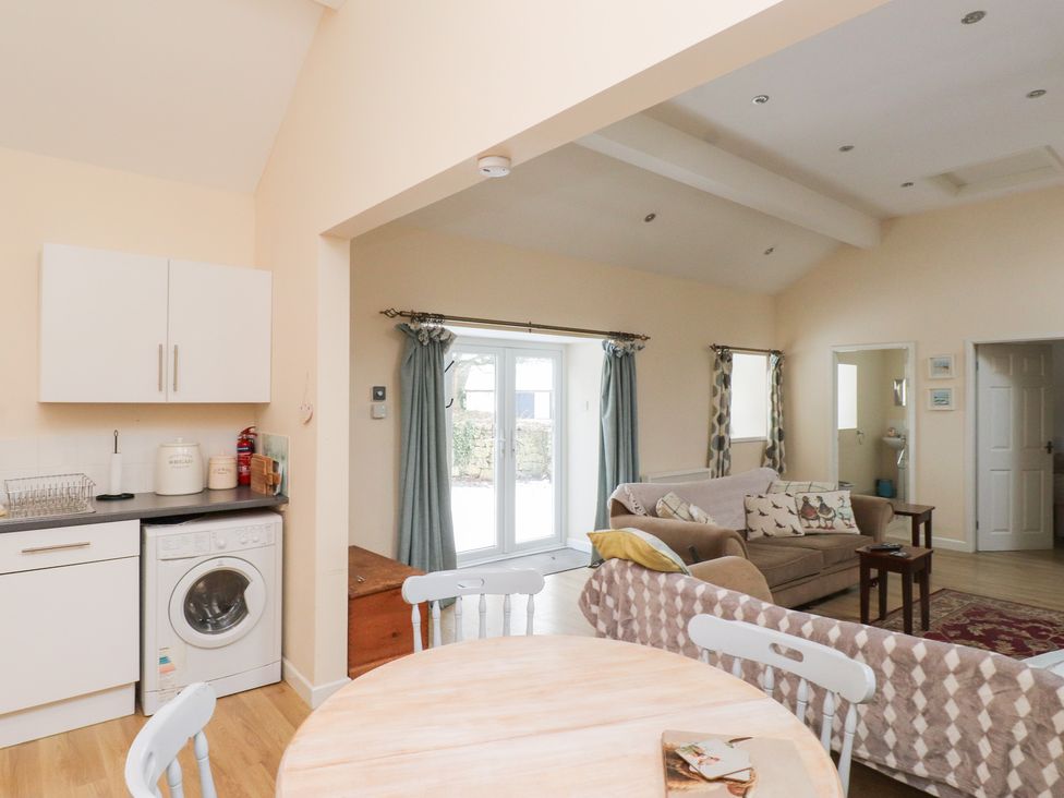 A living room with a sofa and table at Swallow Cottage in Llangefni