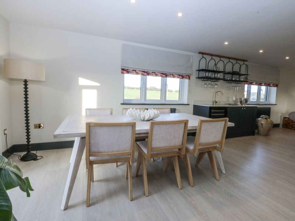 A dining room with a table and chairs at Bell House in Llanfechell