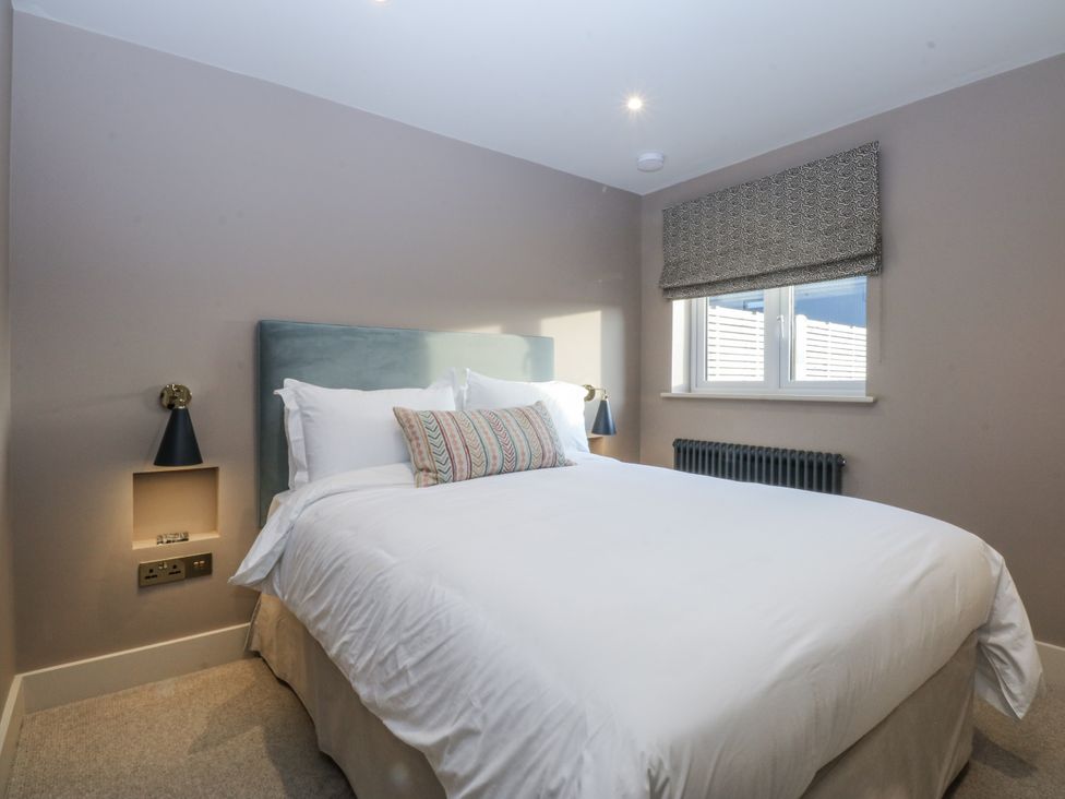 A bedroom with a bed and window at Bell House in Llanfechell