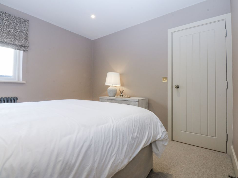 A bedroom with a bed and lamp at Bell House in Llanfechell