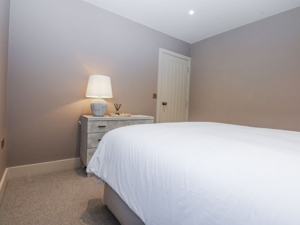 A bedroom with a bed and bedside table at Bell House in Llanfechell