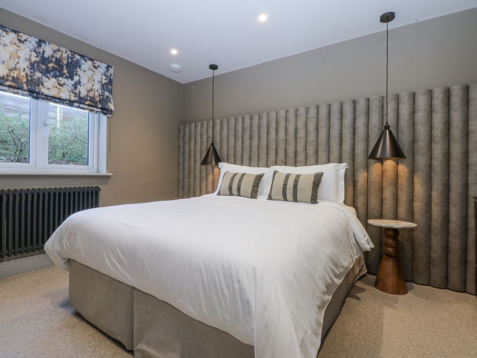 A bedroom with a bed and bedside table at Bell House in Llanfechell
