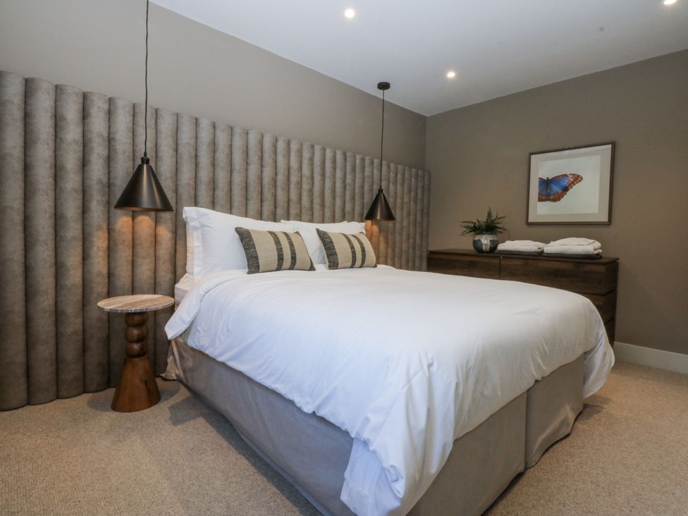 A bedroom with a bed and bedside table at Bell House in Llanfechell