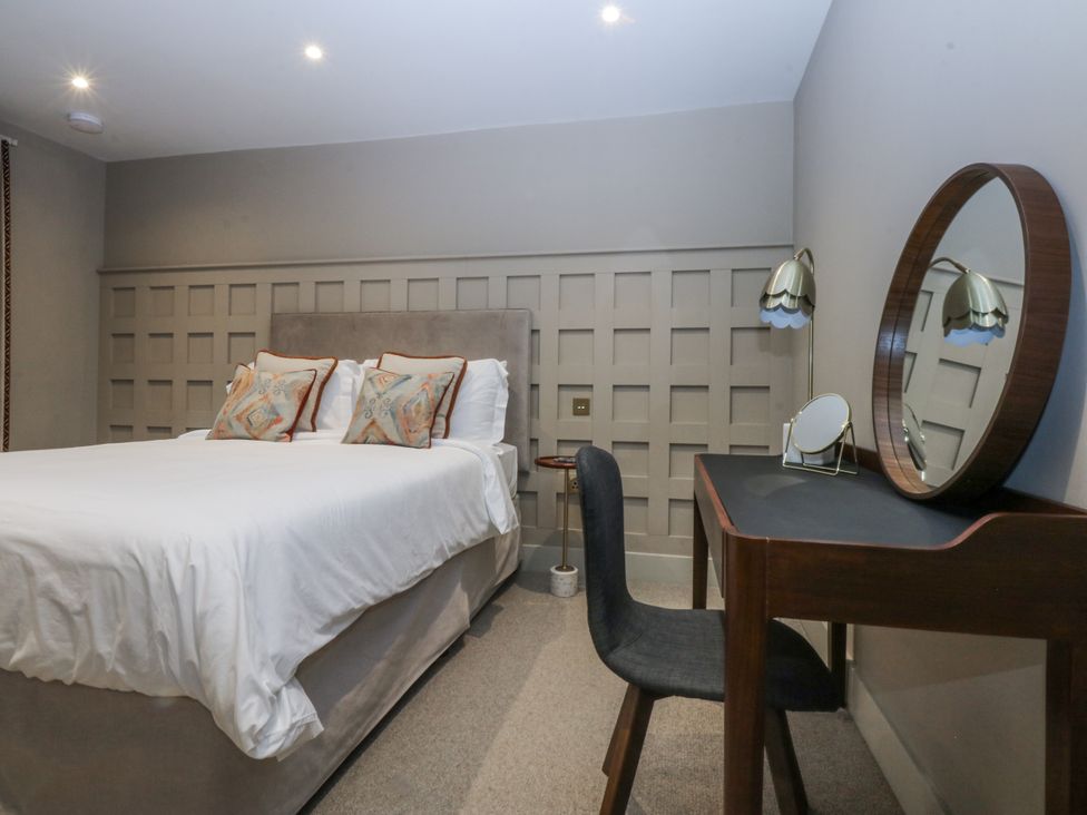 A bedroom with a bed, desk, and chair at Bell House in Llanfechell