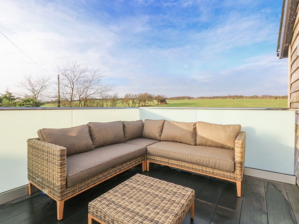 An outdoor seating area with a sofa and coffee table at Bell House in Llanfechell