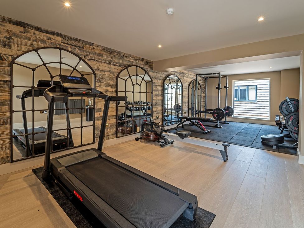A gym with treadmill and weight equipment at Bell House Llanfechell
