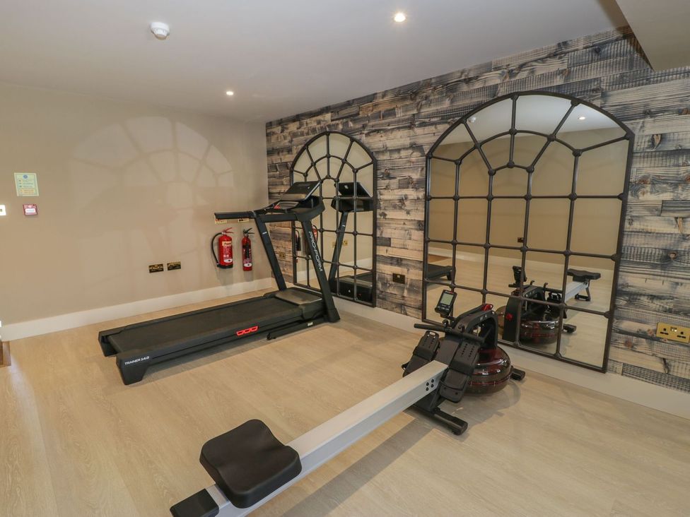 A gym with treadmill and rowing machine at Bell House in Llanfechell